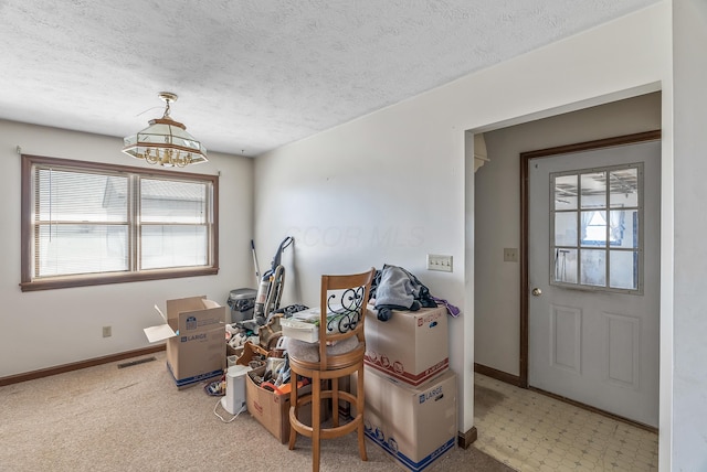 interior space featuring a chandelier, visible vents, a textured ceiling, and baseboards