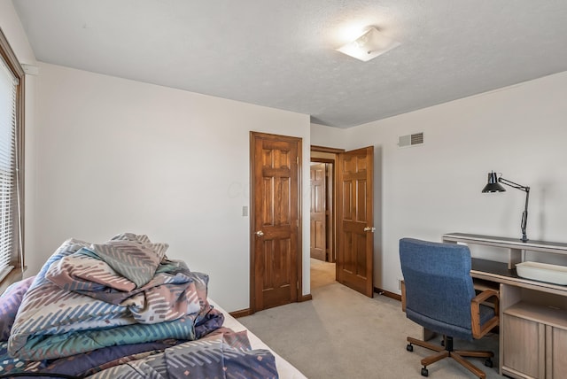 carpeted bedroom with visible vents, baseboards, and a textured ceiling