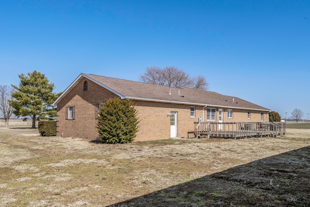 rear view of property with a deck and brick siding