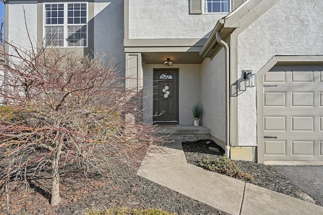 property entrance with stucco siding and a garage