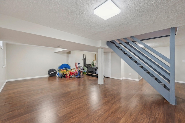 interior space featuring wood finished floors, baseboards, and a textured ceiling