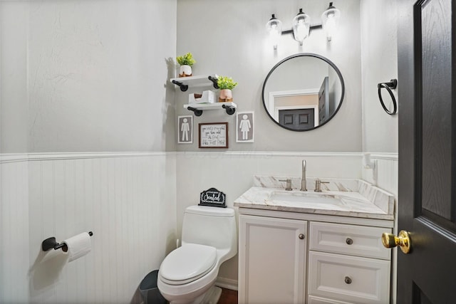 bathroom with wainscoting, toilet, and vanity