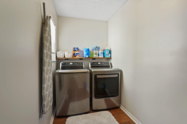 laundry room with dark wood-style floors, baseboards, laundry area, a textured ceiling, and washing machine and dryer