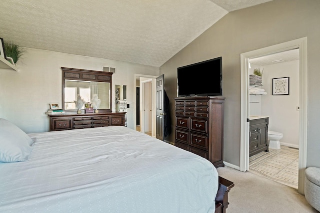 carpeted bedroom with visible vents, a textured ceiling, ensuite bath, baseboards, and vaulted ceiling