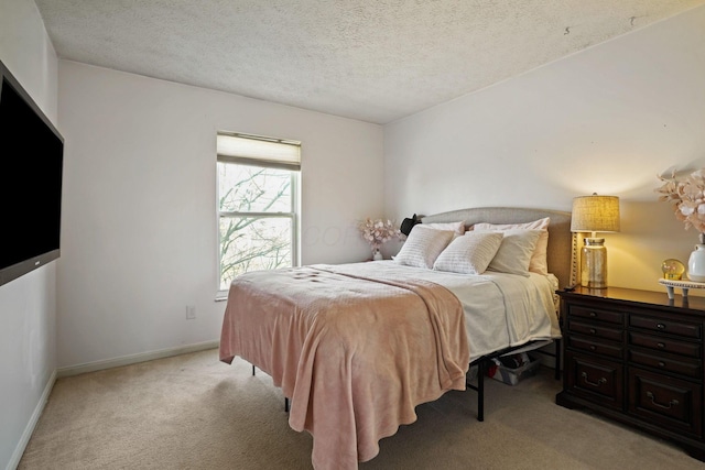 bedroom featuring light carpet, a textured ceiling, and baseboards