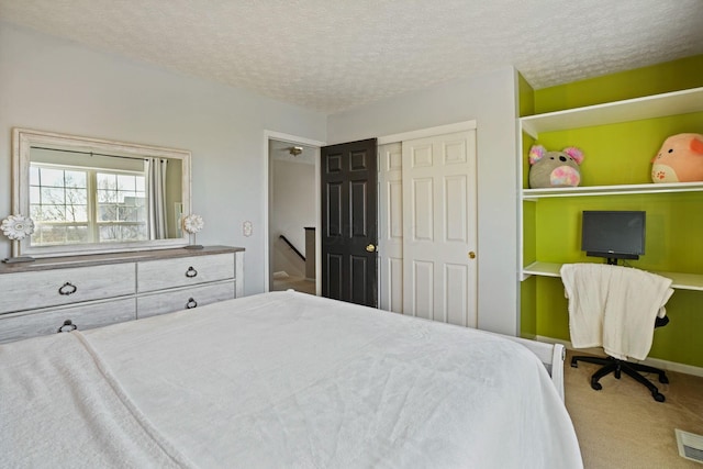 bedroom featuring a closet, carpet floors, and a textured ceiling