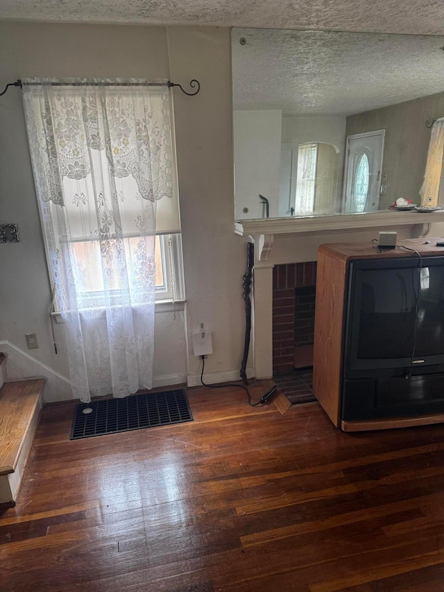 1767 Forest St, Columbus, OH 43206 - unfurnished living room with washer / clothes dryer, wood finished floors, baseboards, and a textured ceiling