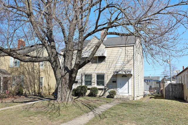 view of front facade with a front lawn and fence