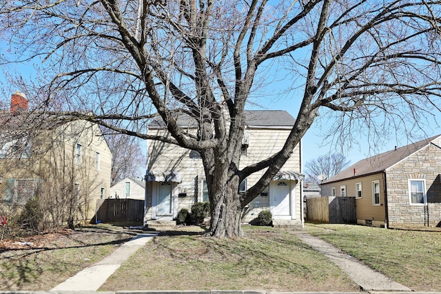 view of front of home featuring a front lawn, fence, and stone siding