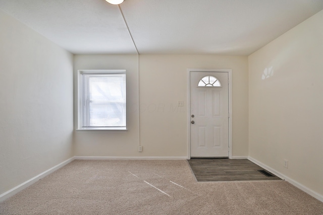 carpeted entrance foyer with visible vents and baseboards