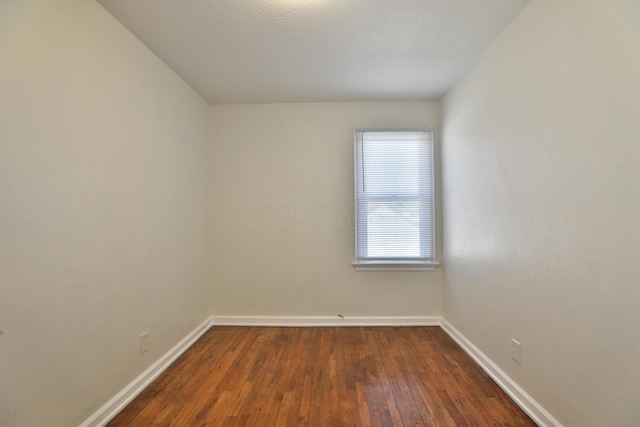 unfurnished room with dark wood-style floors and baseboards