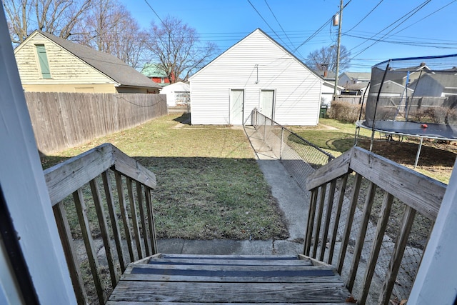 view of yard featuring a trampoline and fence