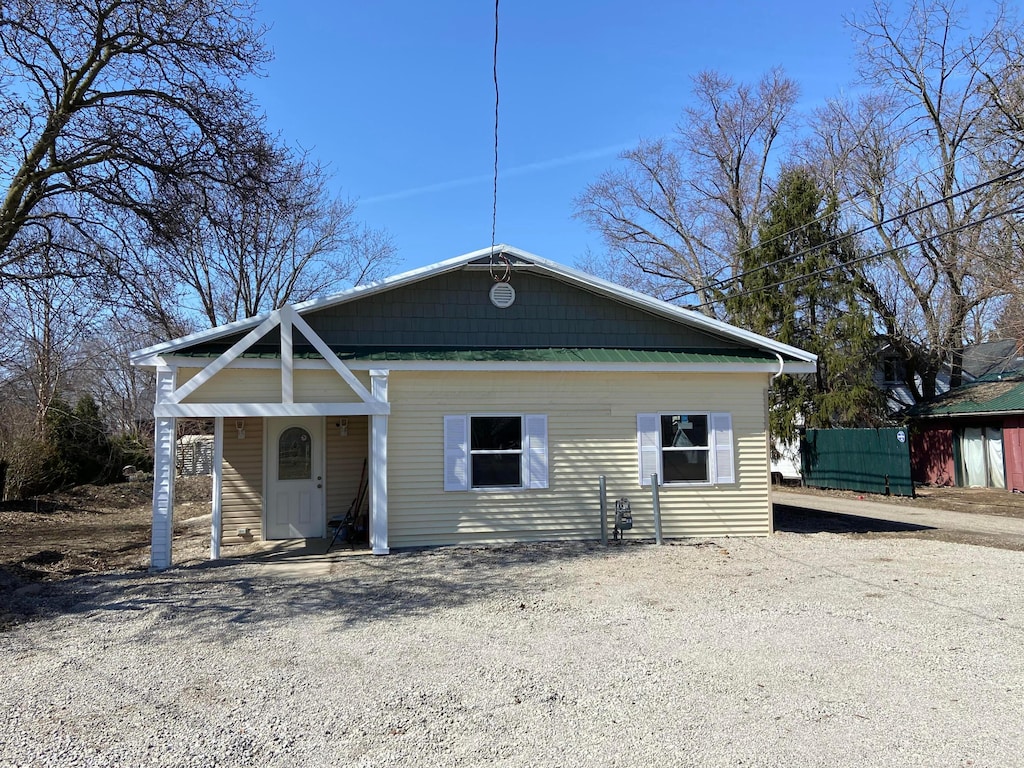 view of front facade with gravel driveway and fence