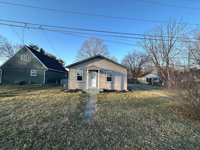 bungalow featuring central AC unit and a front lawn