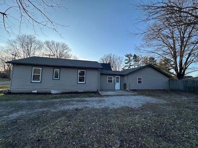 back of property featuring a patio, roof with shingles, and fence