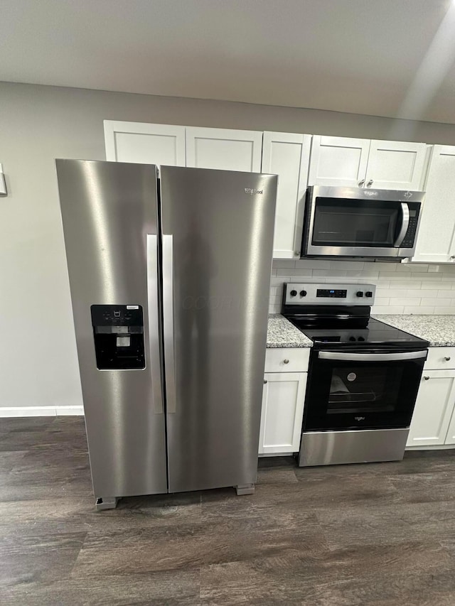 kitchen featuring white cabinets, backsplash, dark wood-style floors, and appliances with stainless steel finishes