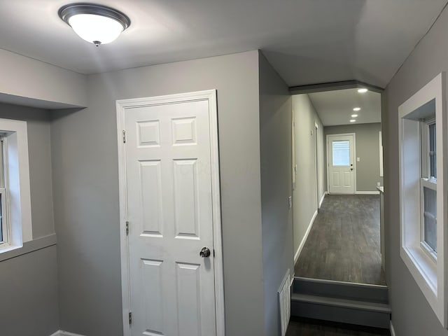 hall with baseboards and wood finished floors