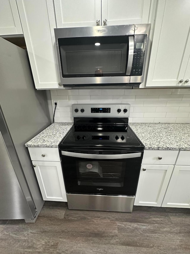 kitchen featuring backsplash, appliances with stainless steel finishes, dark wood finished floors, and white cabinetry