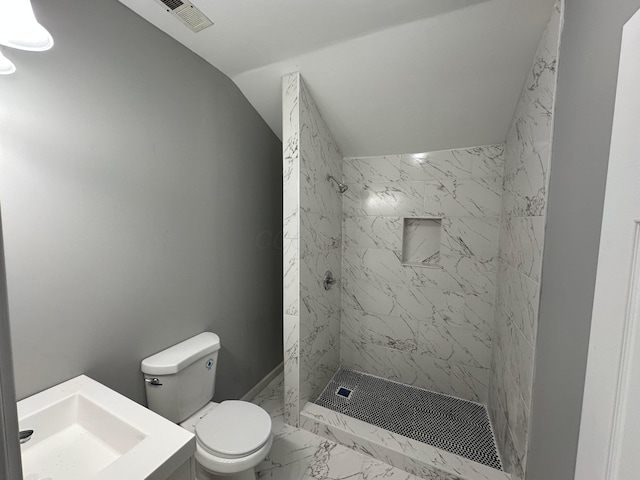 full bathroom with visible vents, a tile shower, vaulted ceiling, toilet, and marble finish floor