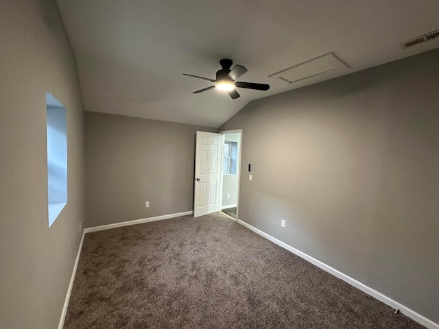 unfurnished bedroom featuring baseboards, visible vents, attic access, lofted ceiling, and carpet flooring