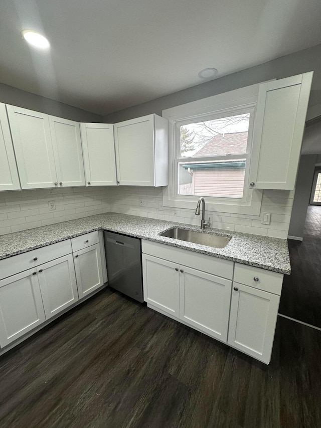 kitchen with a sink, backsplash, dishwasher, white cabinetry, and dark wood-style flooring