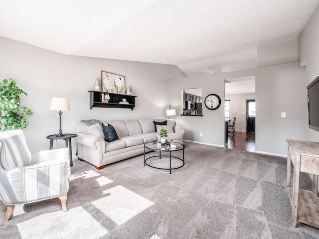 living area with baseboards, carpet floors, and lofted ceiling