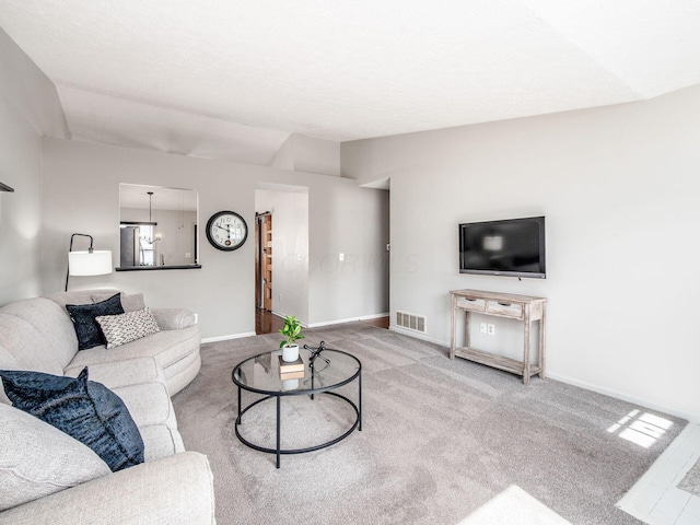 living room featuring carpet flooring, baseboards, and visible vents