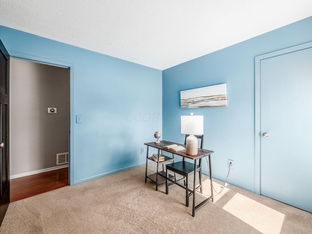 home office featuring visible vents, baseboards, carpet, and a textured ceiling