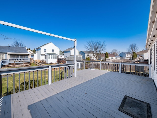 wooden terrace with a residential view and a lawn