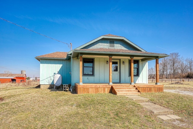 bungalow with a porch, a front lawn, and board and batten siding