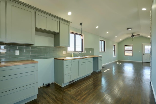 kitchen with a sink, dark wood-style floors, tasteful backsplash, and butcher block countertops