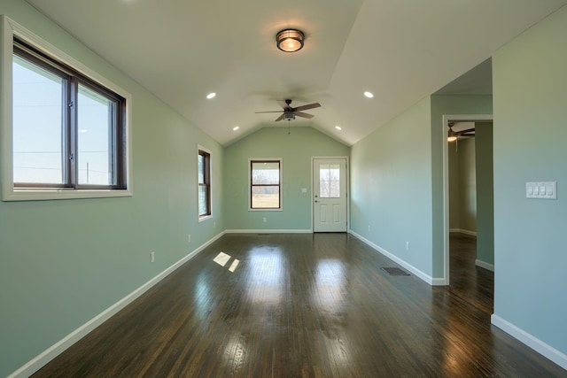 spare room with visible vents, baseboards, dark wood finished floors, vaulted ceiling, and recessed lighting