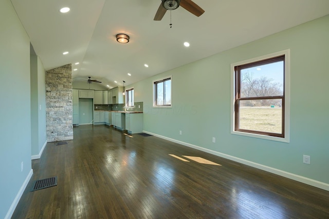 unfurnished living room featuring a ceiling fan, visible vents, baseboards, dark wood-style flooring, and vaulted ceiling