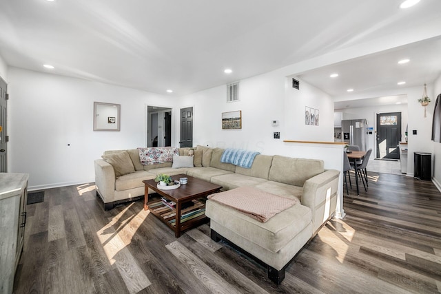 living area with recessed lighting, visible vents, and dark wood-style flooring