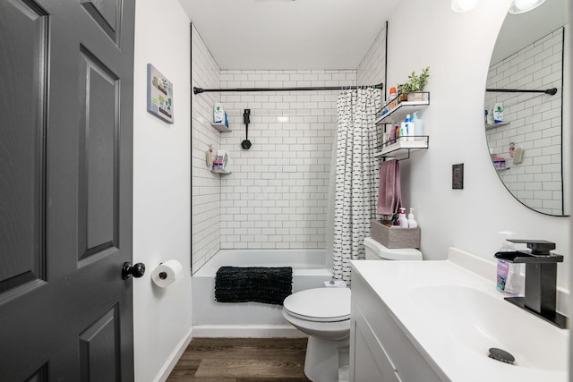 full bath featuring baseboards, toilet, shower / bath combo, wood finished floors, and vanity