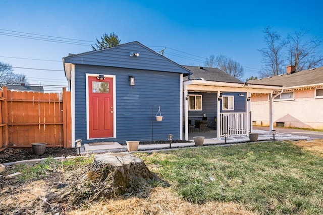 back of property featuring a patio area, a lawn, and fence