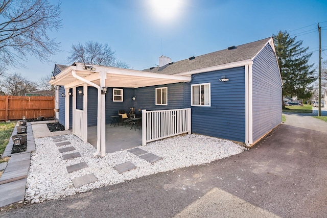 back of property featuring a patio and fence