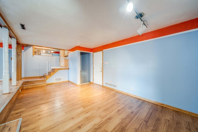 interior space featuring visible vents, light wood-style flooring, and baseboards