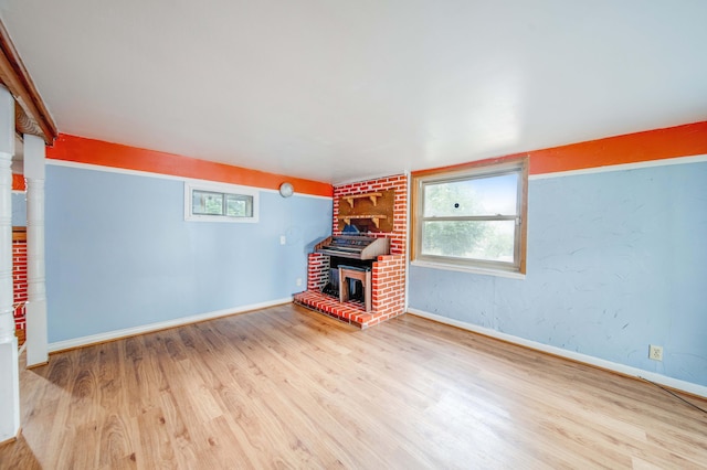 unfurnished living room with a fireplace, wood finished floors, and baseboards