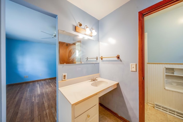 bathroom featuring a sink, a baseboard radiator, wood finished floors, and ceiling fan