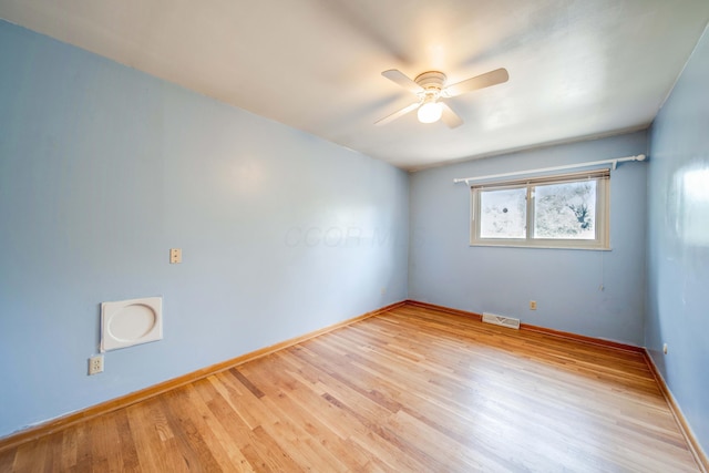 spare room featuring ceiling fan, visible vents, baseboards, and wood finished floors