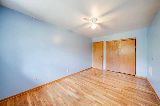 unfurnished bedroom with a ceiling fan, light wood-type flooring, and baseboards