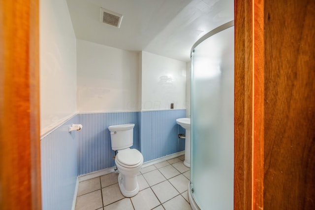 bathroom featuring a wainscoted wall, visible vents, tile patterned flooring, walk in shower, and toilet