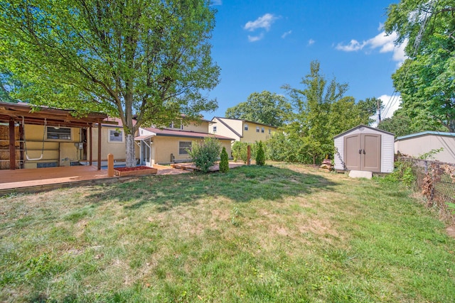 view of yard featuring an outdoor structure, fence, and a shed