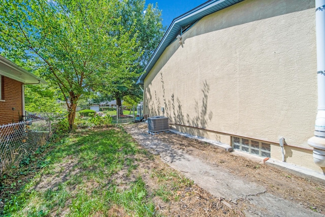 view of yard with central AC unit and fence