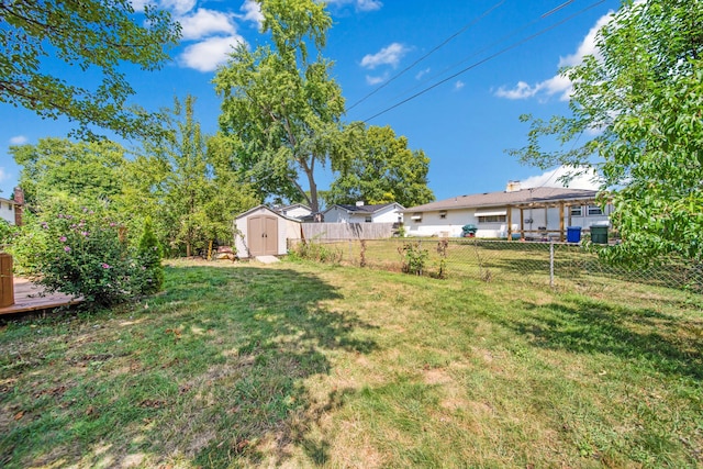 view of yard featuring an outbuilding, a storage shed, and a fenced backyard