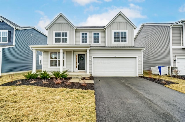 view of front of house with a porch, an attached garage, board and batten siding, and aphalt driveway