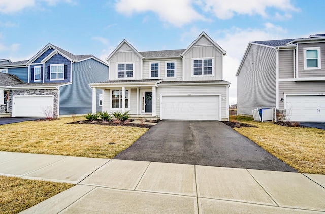 view of front facade featuring a front lawn, a garage, board and batten siding, and driveway