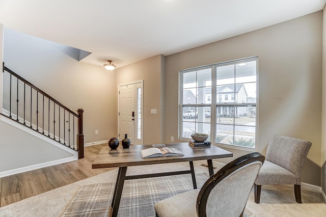 home office featuring baseboards, a healthy amount of sunlight, and wood finished floors