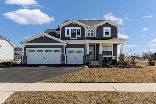 craftsman-style house featuring aphalt driveway, stone siding, and a porch